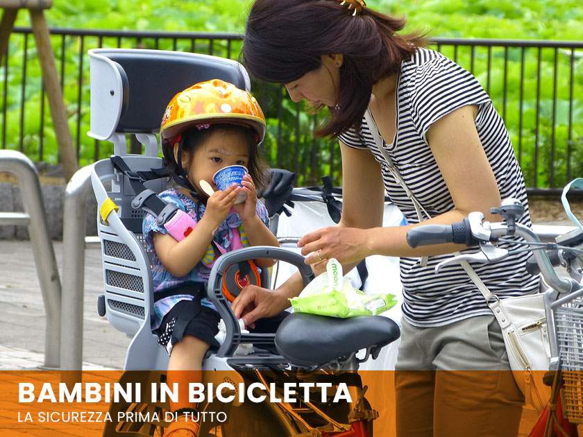 Bambina nel seggiolino bici porta bambini