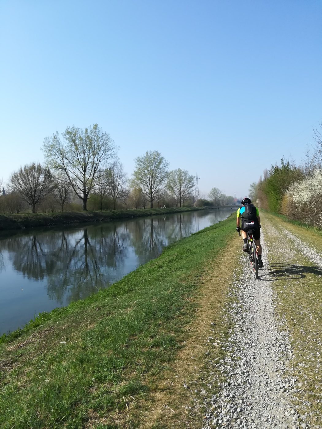 Ciclista gravel lungo un argine in Lombardia